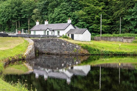 Lock Keepers Cottage reflected in the pool below lock 11, Argyll and Bute, Scotland, United Kingdom