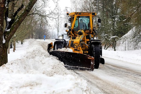 Yellow motor grader Vammas removing snow from street after heavy snowfall in Salo, Finland. January