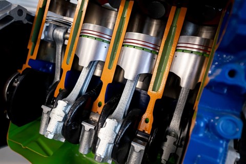 Car engine cut-through view. Four-cylinder straight-four engine piston engine sliced in half
