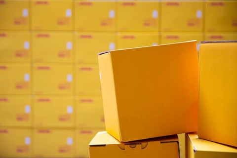 Yellow transportation boxes packages are seen arranged in a warehouse