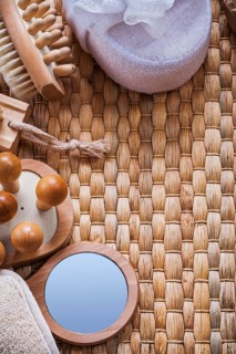 Vanity mirror wooden massagers nail brush and soft bath sponges on wicker background sauna concept