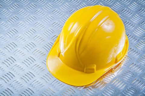 Safety building helmet on grooved metal plate construction concept