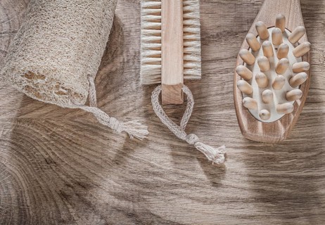 Composition of scrubbing loofah massager bath brush on wooden board spa treatment concept