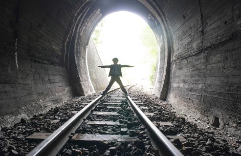 Child walking in railway tunnel. Vintage clothes