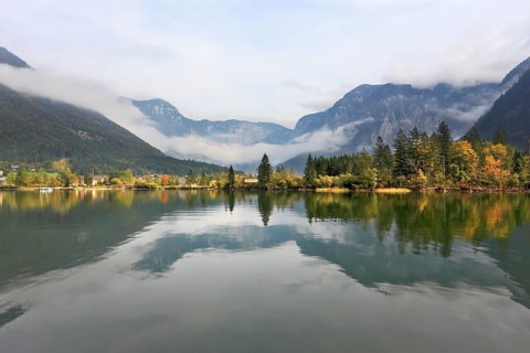 The picturesque shores of Lake Hallstatt. Mountains reflected in the smooth water of the lake