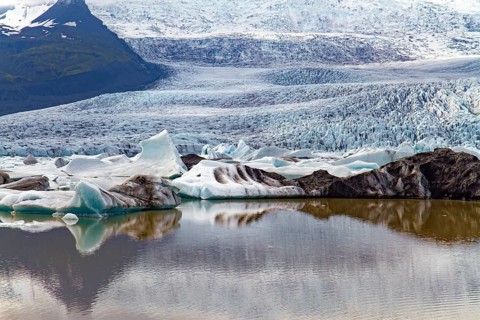 Blocks of ice are reflected in smooth water. Jokulsarlon glacial lagoon. The imposing scenic lagoon