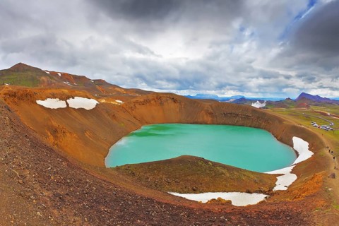 July in Iceland. Lake in the crater of an extinct volcano. Lake water bright green color. On the