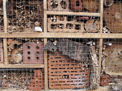 Insect hotel with bricks, bamboo sticks, bark and logs
