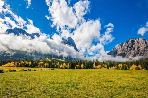 Shining sunny day in Canmore. Concept of hiking. The Three Sisters mountains in the Canadian