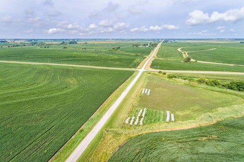 Aerial view of rural Nebraska landscape with a farm road, soybean field and hay bales