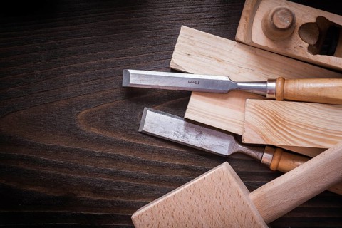 Lump hammer shaving plane flat chisels and wooden bricks on brown board construction concept