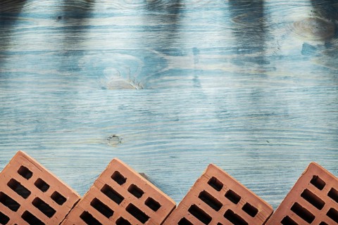 Red bricks on wooden board horizontal version building concept