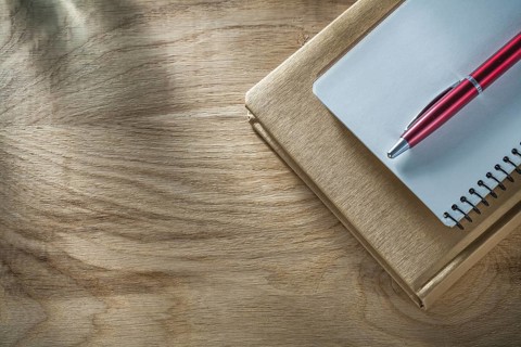 Vintage notepads pen on wooden board