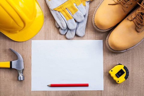 Blank sheet of paper with pencil tape measure claw hammer helmet protective gloves work boots