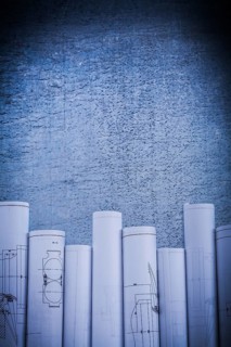 Scratched metallic surface with blueprint rolls construction concept