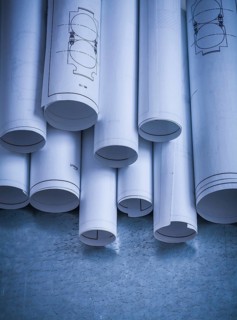 Heap of engineering drawings on scratched metallic background building and architecture concept