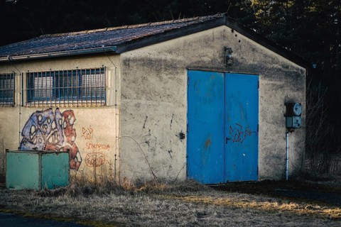 Wildberg, Calw, Baden-Württemberg, Germany, Rural hut with blue door and graffiti in front of