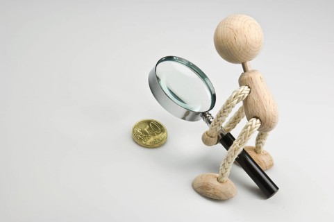 Wooden figure holding a magnifying glass over a 50 euro cent coin, Federal Republic of Germany