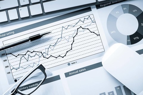Business workplace with keyboard mouse and papers with graphs and diagrams