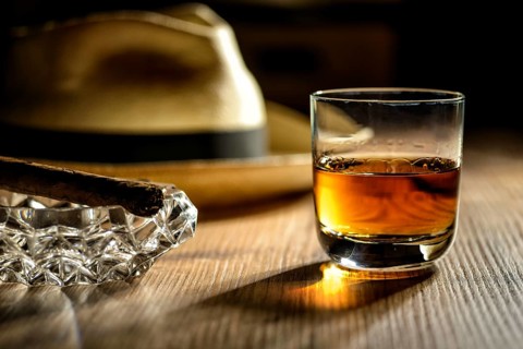 A glass of rum, a cigar and a Panama hat in a bar in Cuba