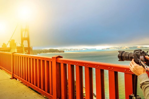 Camera taking a shot of Golden Gate Bridge and red railing, San Francisco, California, United