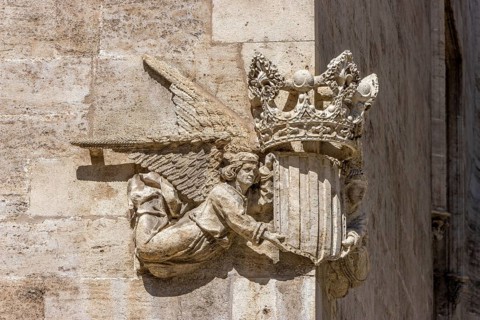 Stone sculpture of two angels with the coat of arms and crown of Valencia on the corner of a stone