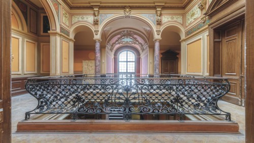 Historic balcony in an empty room with wrought-iron railings and columns, Villa Woodstock, Lost