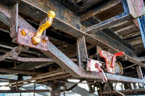 Close-up of rusty wagons with distinctive red levers on a structure, 27568 Bremerhaven