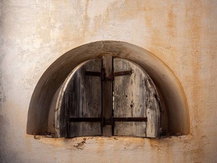 A picture of a rusty window of an abandoned fortress