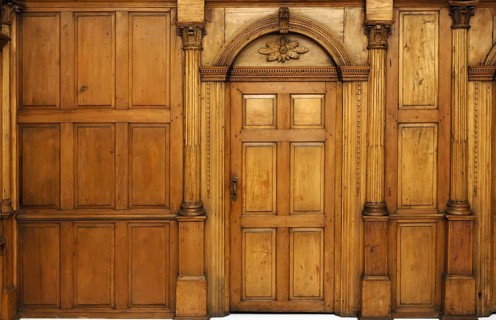 Wooden paneled wall and an arched door Victorian architecture style interior