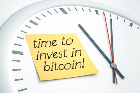 3D illustration of a bright clock with a sticky note and the message time to invest in bitcoin