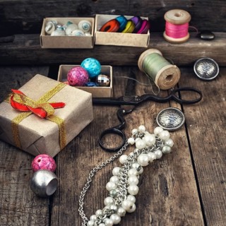 Old scissors, spools of thread, buttons and beads on wooden table