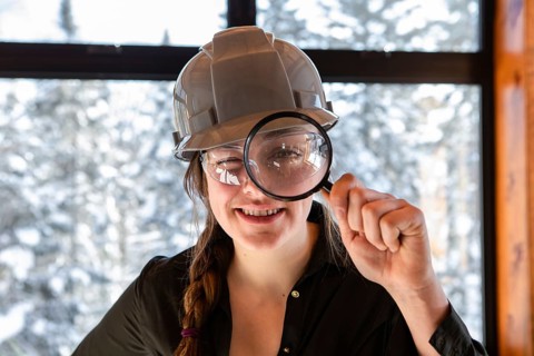 Caucasian worker woman smiling. construction inspector looking through a magnifying glass. she