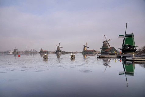 Windmills along the river Zaan in the Dutch traditional village Zaanse Schans which is one of the