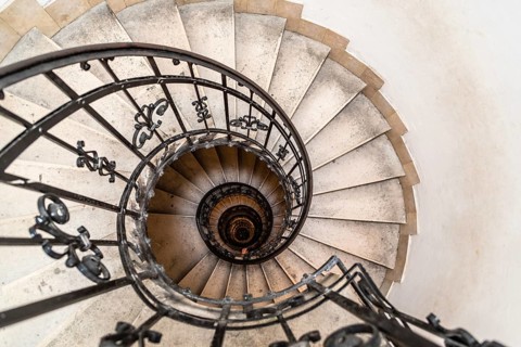High angle view of spiral staircase with hand of man below