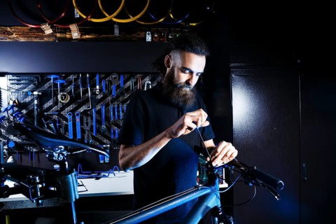 Theme sale and repair of bicycles. Young and stylish with a beard and long hair, a Caucasian man