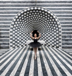 Ballerina in a black tutu poses in front of modern, stripe-patterned, symmetrical granite
