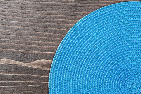 Blue wicker table matting on wooden board