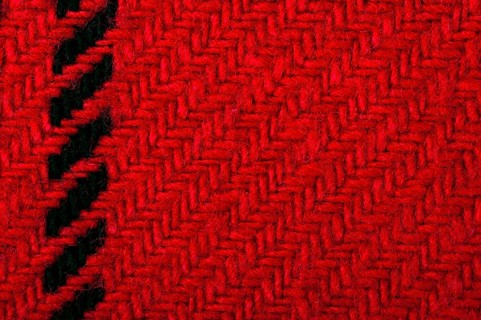 Handmade knit black and red background. Close up structure of the yarn. Christmas colors