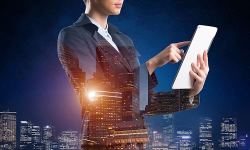 Businesswoman using tablet computer. Double exposure concept with night city and woman in business