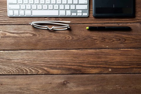 Top view office workspace composition. Flat lay vintage wooden desk with pc keyboard and graphic