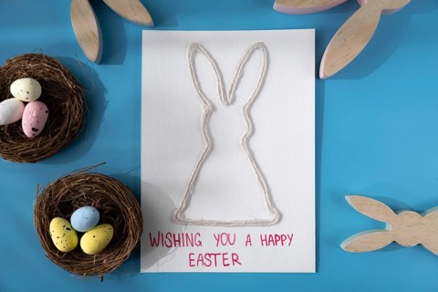 Handmade greeting card with EASTER bunny HAPPY EASTER written in beautiful handwriting. Gesture