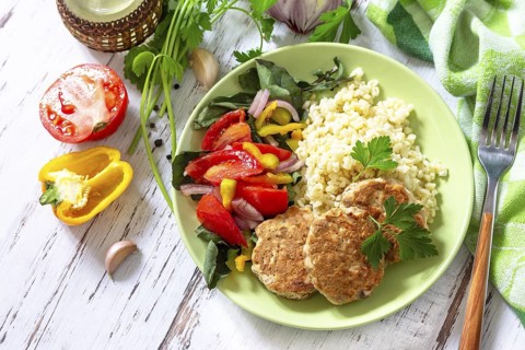 Healthy vegan food, keto or paleo diets. Homemade red fish cutlets with bulgur and fresh vegetable