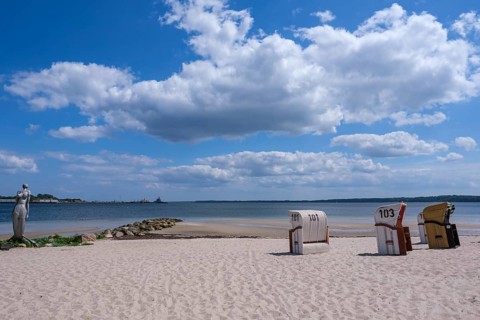 A quiet beach with beach chairs and a sculpture at the water's edge, Eckernförde,