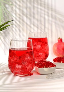 Pomegranate fruit juice and ingredients, summer pomegranate drink on bright table, detox diet and