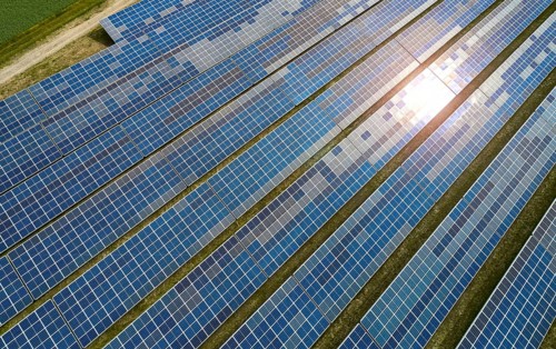 Solar panel field at work with sun reflection