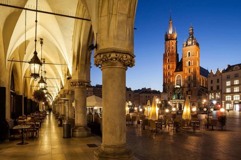 City of Krakow by night in Poland, Main Square in the Old Town with St. Mary Church from the arcade