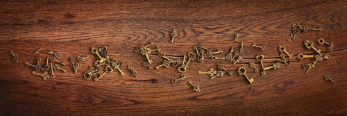 Magical bronze keys on a wooden oak surface in panorama format