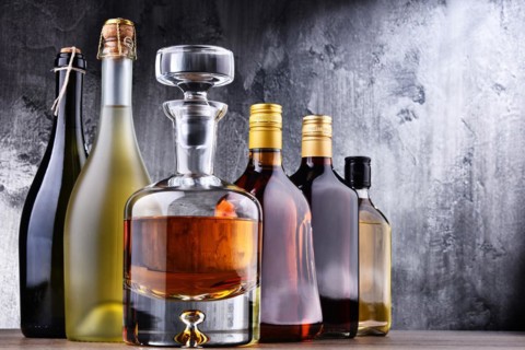 Composition with carafe and bottles of assorted alcoholic beverages