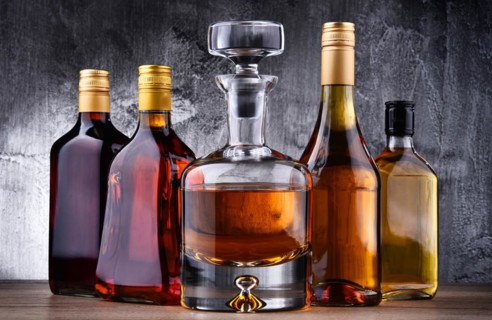 Composition with carafe and bottles of assorted alcoholic beverages